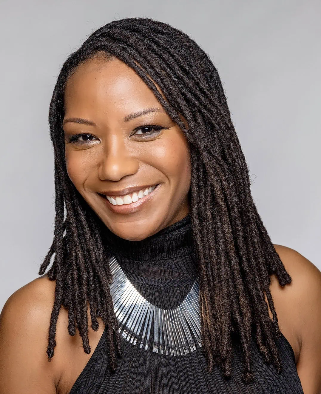 Close-up of Roxanne smiling into the camera. She is available for wardrobe makeover speaking engagements and more.