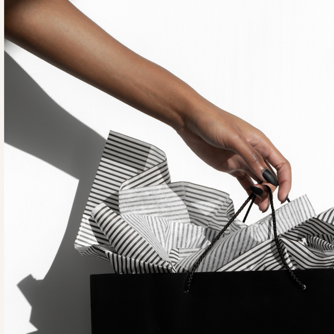 Woman's hand holding shopping bag from sale.